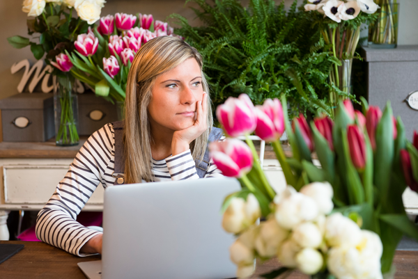 florist-worker-in-flower-shop-using-laptop-stressed